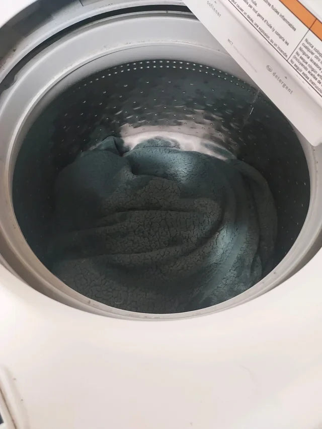 Fresh laundry beside a washing machine in a home with pets