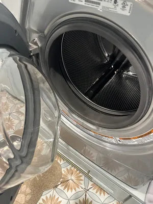 Customer inspecting a freshly cleaned washing machine after using DeepRinse