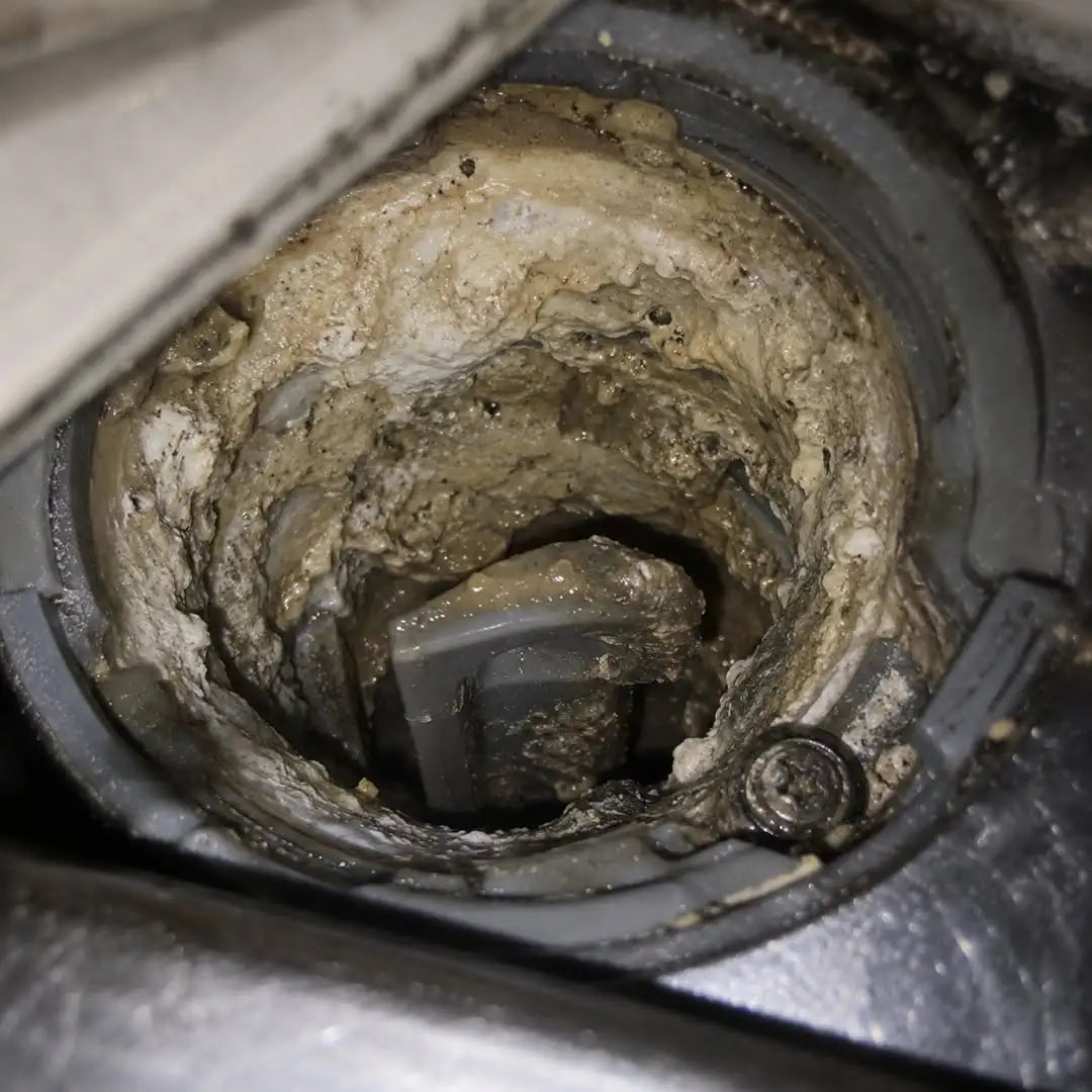 Heavy hard water buildup inside a hidden dishwasher component